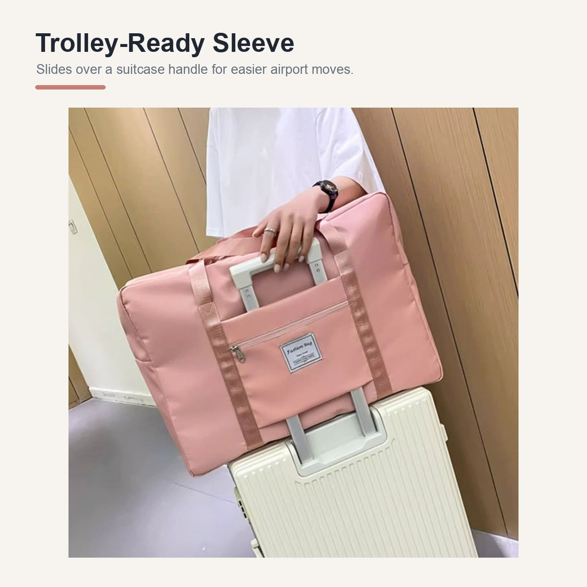 Pink medium travel duffel secured over a suitcase handle